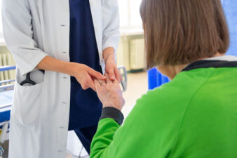 Lääkäri hoitaa iäkästä potilasta.